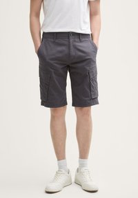 Shorts cargo gris avec deux poches latérales, fabriqués en tissu durable, présentant une coupe décontractée et une fermeture boutonnée à la taille.