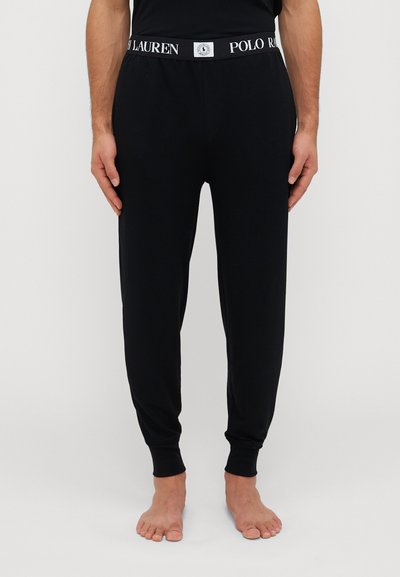 Pantalons de jogging noirs en tissu doux, avec une taille élastique blanche arborant le logo "POLO LAUREN", coupe ajustée avec des jambes cintrées.