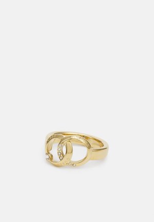 Anillo de oro con dos círculos entrelazados grabados con "GUESS" y "FOREVER", decorado con pequeños cristales incrustados.