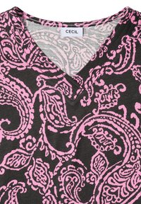 T-shirt gris foncé à col en V avec des motifs cachemire roses et complexes et une étiquette blanche portant la mention "CECIL" à l’encolure.