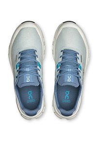 Light blue mesh athletic shoes with a textured upper, contrasting dark blue laces, and white rubber soles. Features brand logo on the tongue.
