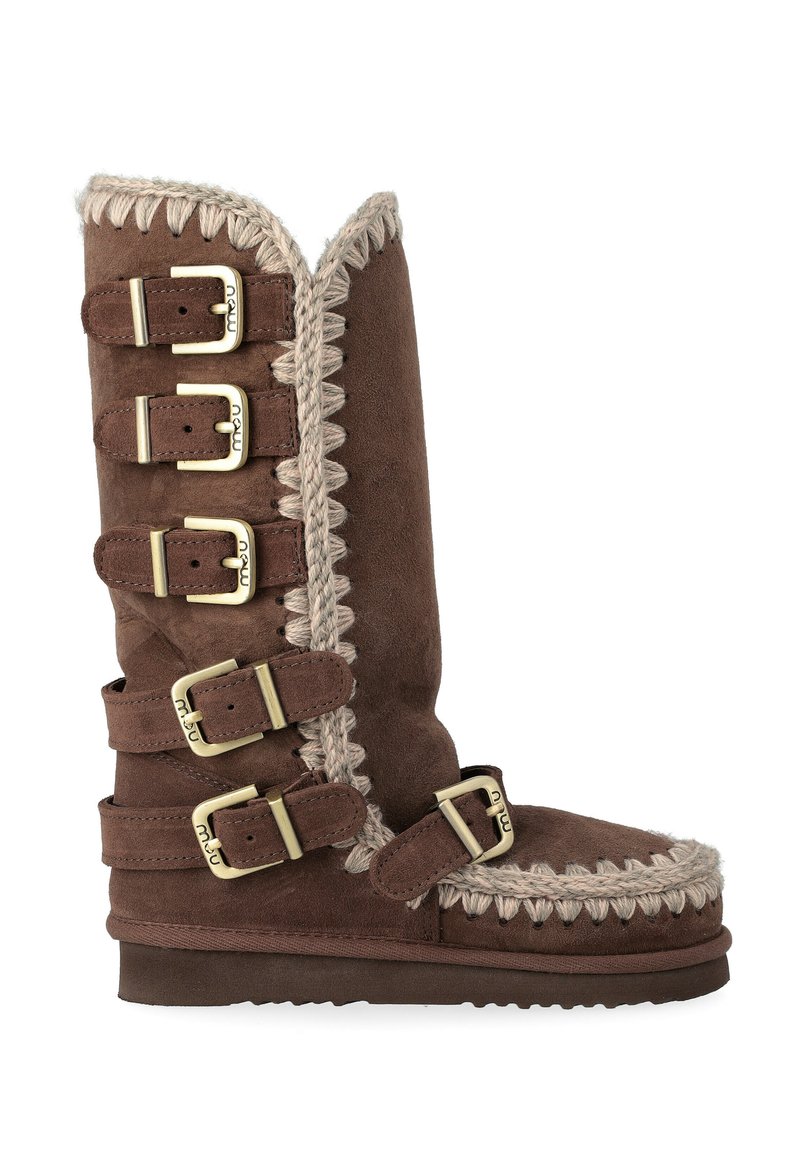 Stivale in suede marrone al ginocchio con dettagli intrecciati, cinque fibbie e bordo superiore leggermente scallopato. Suola testurizzata per la presa.