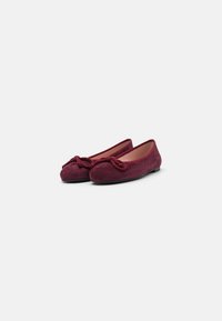 Ballerines en suède bourgogne avec un bout arrondi, ornées d'un accent noué décoratif sur le devant. Doublure intérieure lisse, semelle plate.