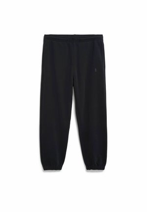 Black sweatpants made of soft, stretchy fabric. Features an elastic waistband, tapered legs, and elastic cuffs at the ankles.