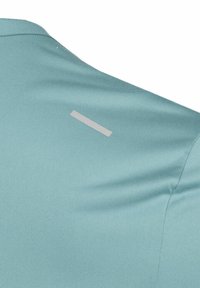 Camisa deportiva de color verde azulado con mangas cortas, que presenta una textura suave y una franja de acento gris reflectante en la zona del hombro trasero.
