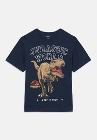 Navy krāsas kokvilnas T-krekls ar lielu dinozauru grafiku, tekstu "Jurassic World" un apaļu logo ar uzrakstu "Keep It Wild" apakšā.