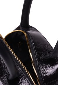 Borsa a spalla in pelle verniciata nera con apertura a zip, hardware della zip dorato, superficie texturizzata e due robuste maniglie. L'interno è foderato in tessuto.