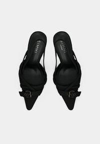 Čierne lodičky s ostrou špičkou, látkovými remienkami a dekoratívnou prackou. Hladká textúra a otvorený zadný dizajn pre minimalistický vzhľad.