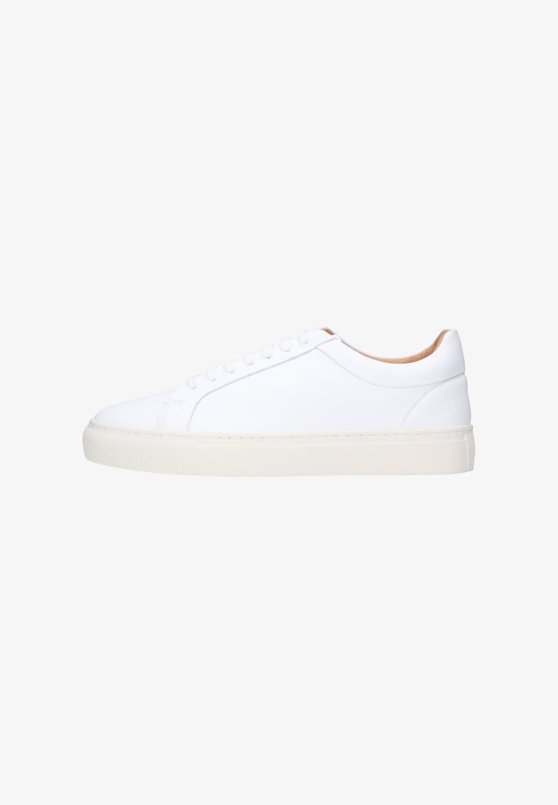 Witte leren laagmodel sneaker met witte veters en dikke off-white rubberen zool, zijaanzicht op een witte achtergrond.