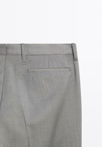 Graue maßgeschneiderte Hose mit einer glatten, strukturierten Oberfläche. Verfügt über einen Standardbund und eine einzelne Gesäßtasche. Designer-Nähte sind sichtbar.