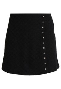 Jupe noire en tissu texturé, ornée de clous carrés argentés sur un côté pour la décoration et d'un ourlet légèrement évasé.