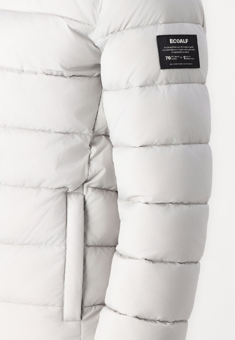 Chaqueta de plumas gris claro con diseño acolchado, que cuenta con un bolsillo lateral y una etiqueta Ecoalf negra en la manga. Textura suave y lisa.
