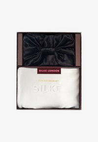 Zestaw z czystego jedwabiu z czarną jedwabną chustą na włosy i białą jedwabną poszewką na poduszkę, z wytłoczonym napisem i eleganckim opakowaniem.