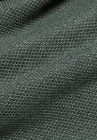 Tissu tricoté de couleur vert foncé, présentant un motif texturé en forme de gaufre qui met en valeur sa douceur et sa texture tissée.