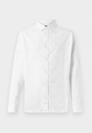 Vit långärmad skjorta i bomull med subtil mönstrad broderi över hela, krage med knappar och knappstängning fram.
