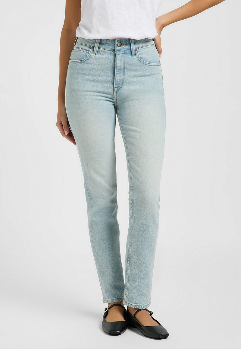 Jeans in denim blu chiaro con vita alta, gamba dritta, design a cinque tasche e leggero sbiadimento, abbinati a scarpe flat nere.
