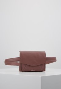 Bolso de cuero marrón con cierre de tapa, que presenta costuras blancas en contraste y una sola correa. Diseño rectangular compacto.