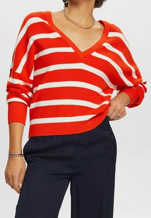 Pull en tricot rayé rouge et blanc avec un col en V et une coupe ample, doté de poignets retroussés et d'une ourlet arrondi.