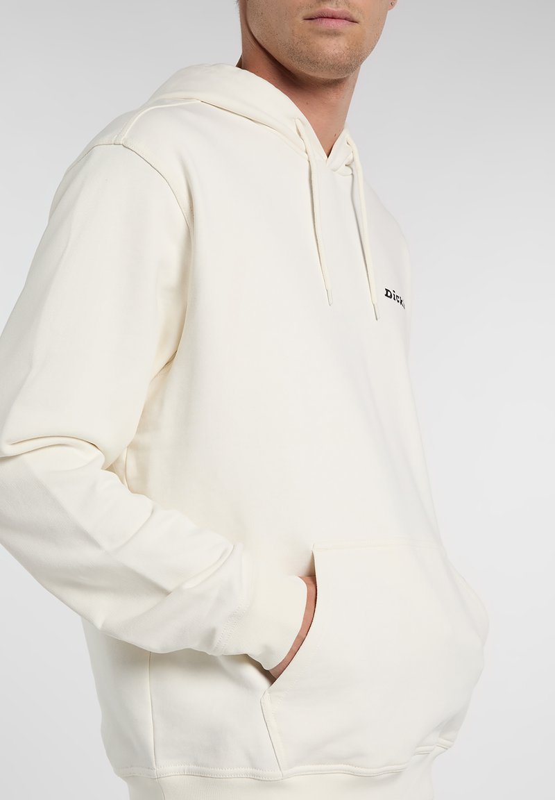 Lichtbeige hoodie met trekkoorden, voorzak en geribbelde manchetten. Voorzien van een klein zwart logo op de borst. Gladde textuur.