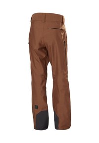 Bruine skibroek van textuurstof met een rechte pijpdesign; beschikt over zijritszakken en zwarte accenten aan de onderkant van de benen.