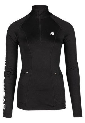 Zwarte lange mouwen sporttop met een half-rits halslijn, zijzakken met rits en een logo op de borst en mouw, gemaakt van rekbaar materiaal.