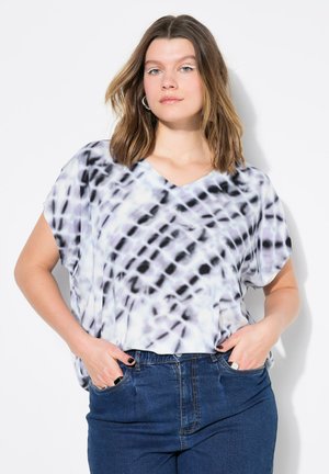 Letvæg V-hals top i et tie-dye mønster af sort og lys lilla, med korte ærmer og afslappet pasform. Kombinationen med højtaljede denim jeans.