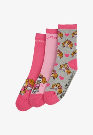 Drei Paar Kindersocken: ein einfarbiger pinker, ein hellpinkfarbener mit Herzen und ein grauer mit einem Cartoonhund und Herzen, alle mit pinken Akzenten.