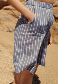 Lichtblauwe gestreepte shorts met een relaxte pasvorm, elastische tailleband, zijzakken en ronde zoom, gemaakt van een zachte, lichtgewicht stof.