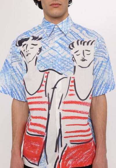 Camisa de manga corta con un fondo estampado en azul y blanco y figuras con rayas rojas contorneadas en negro. Tela de algodón, corte relajado.