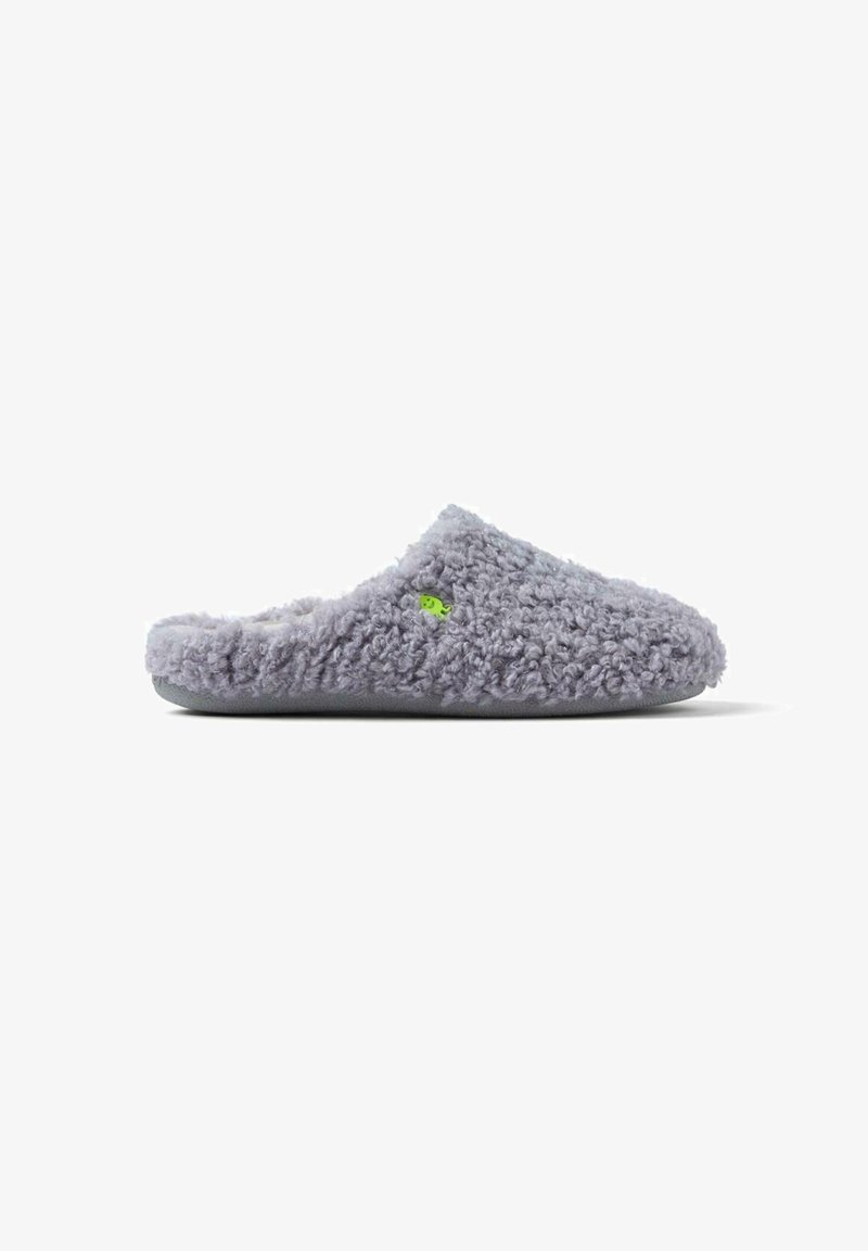 Chausson violet en peluche avec un extérieur texturé et moelleux et un design simple. Présente un logo vert sur le côté et une semelle douce.