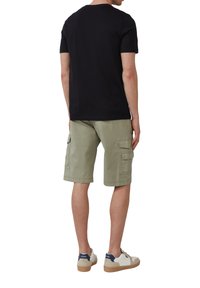 Zwarte T-shirt met korte mouwen, olijfgroene cargoshorts met zijzakken en witte sneakers met marineblauwe accenten en beige zolen.