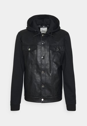 Schwarze Jacke mit Lederfront und schwarzen Stoffärmeln mit Kapuze. Druckknöpfe und zwei Brusttaschen auf dem Lederteil.