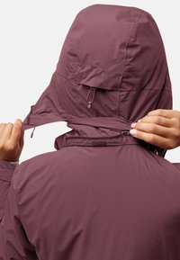 Bordeaux rode hoodie met een gestructureerde afwerking, voorzien van verstelbare koorden en een rits bij de hals. De achterkant is glad met een eenvoudig ontwerp.