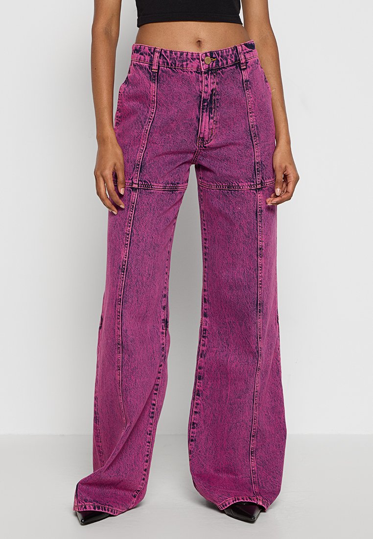 Pantaloni larghi a vita alta in denim rosa vivace. Caratterizzati da cuciture a vista, chiusura con bottone e due tasche frontali.