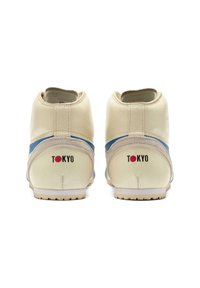 Krämfärgade sneakers med en strukturerad yta, blå detaljer och "TOKYO" tryckt i rött på hälen. Lågprofil design med en gummisula.