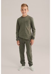 Camisa de manga larga verde oliva con un bolsillo texturizado y pantalones a juego con un estampado de letras en negrita. Tela suave; puños ceñidos en los tobillos.