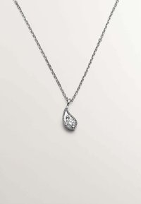 Collar de cadena de plata con un colgante en forma de lágrima que presenta una piedra central clara y pequeños acentos claros a lo largo del borde.