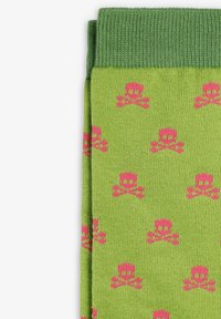 Medias verdes con un puño acanalado, que presentan un patrón repetido de calaveras y huesos cruzados en rosa. Están hechas de un suave tejido de punto.