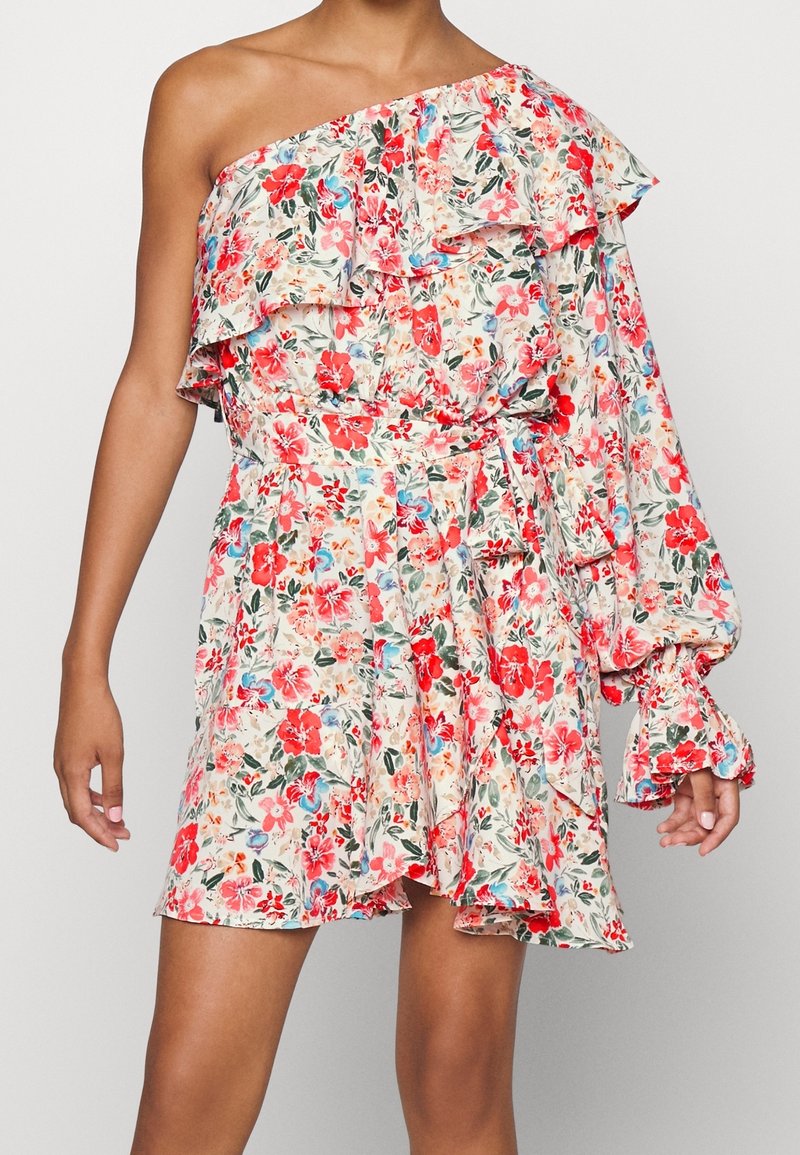 Robe fleurie épaules dénudées avec une manche longue bouffante, un col à volants et une ceinture assortie à la taille en rouge, rose, bleu et vert sur fond crème.