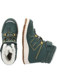 Groene lederen enkellaarsjes met witte bontvoering, rubberen zool, gouden accenten en een verstelbare band. Heeft een gestructureerd patroon en veters.