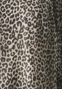 Tessuto a stampa leopardata con sfondo beige e macchie nere e marroni, caratterizzato da una sottile trama a righe.