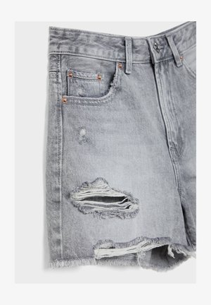 Lysegrå denimshorts med frynset kant og slidte revnede detaljer foran nær lommer og lår.