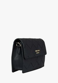 Borsa nera trapuntata con chiusura a patta, caratterizzata da un logo dorato e un attacco per la tracolla sul lato. Texture liscia, forma rettangolare.