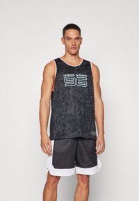 Zwarte sportieve tanktop met een structuurpatroon, lichtblauwe en oranje accenten, met "UNDER ARMOUR 96" gedrukt op de voorkant. Gekleed met zwarte mesh korte broek.