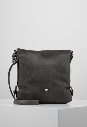 Bolso cruzado de cuero texturizado gris oscuro con una correa ajustable y un pequeño logo plateado en la parte delantera, apoyado sobre una superficie blanca.