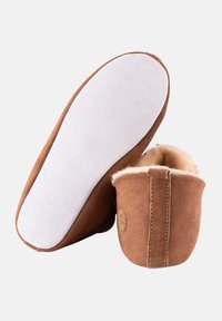 Pantofole in suede marrone con una morbida fodera in shearling beige, dotate di una suola in gomma bianca e una forma a punta arrotondata. Decorate con un dettaglio del logo.