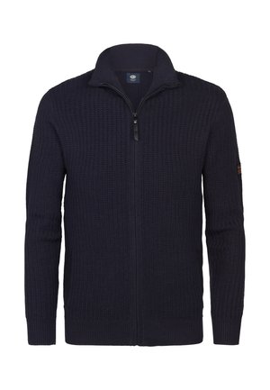 Pull-over zippé en tricot bleu marine avec un col haut, présentant un motif texturé et des poignets côtelés. Détail du logo sur la manche.