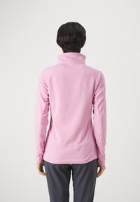 Rosa fleece-pullover med hög krage, långa ärmar och raglanärmar. Mjuk textur och figurnära design.