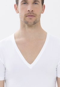 Weißes V-Ausschnitt-T-Shirt aus weichem, glattem Stoff. Kurze Ärmel und ein tiefer V-Ausschnitt, minimalistisches Design, keine sichtbaren Muster oder Akzente.