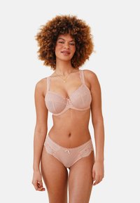 Blush lace lingerie set featuring a balconette bra with polka dots and scalloped edges, paired with matching sheer briefs and a central bow detail.